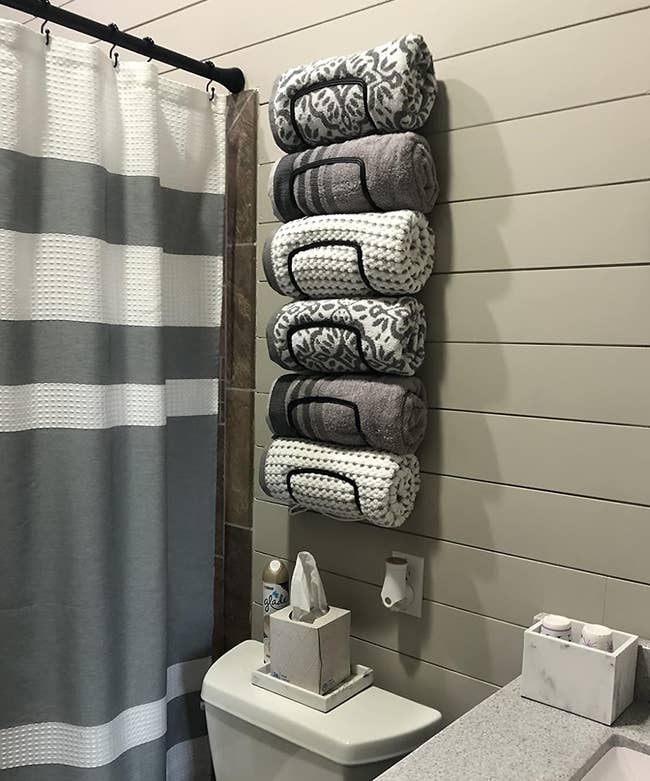 reviewer's mounted towel rack holding six towels
