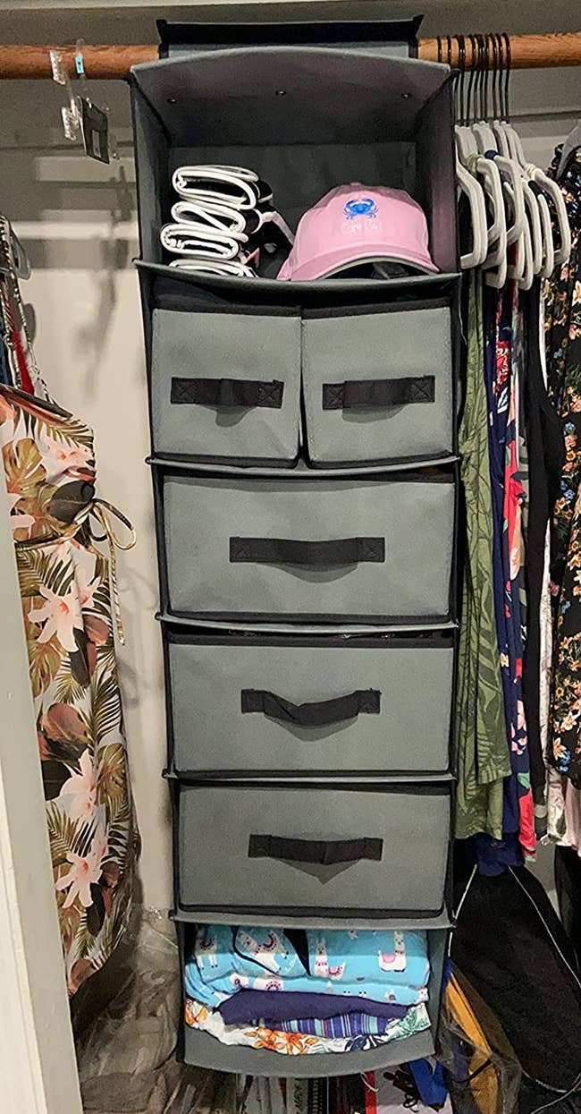 a reviewer photo of the drawer organizer hung in a closet 