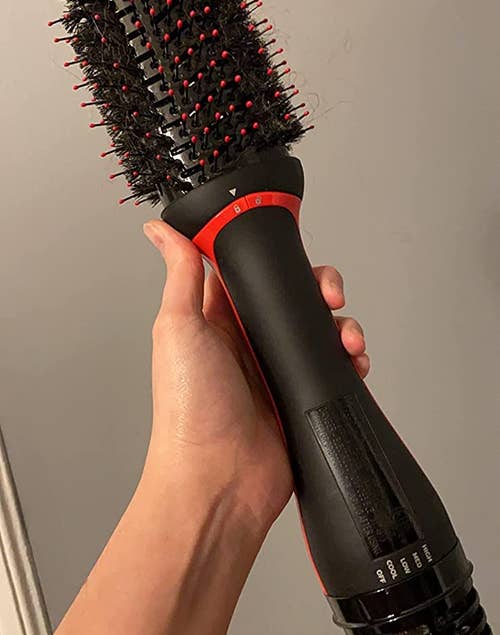 a reviewer holding the round hot air brush 