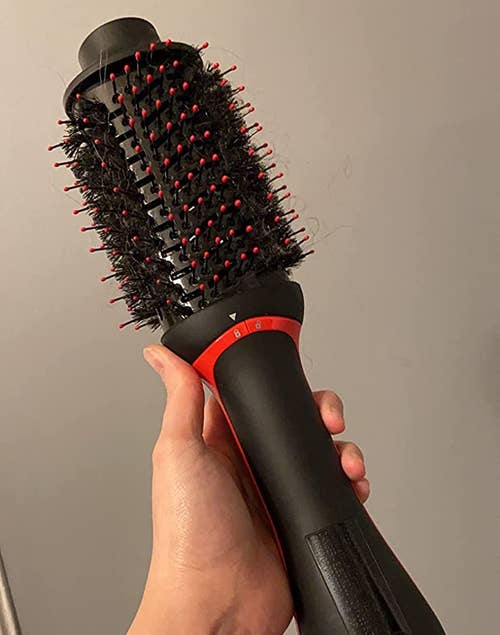 a reviewer holding the round hot air brush 