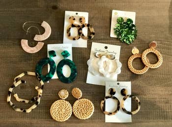 nine pairs of various earrings in hoops and drop down and woven designs 