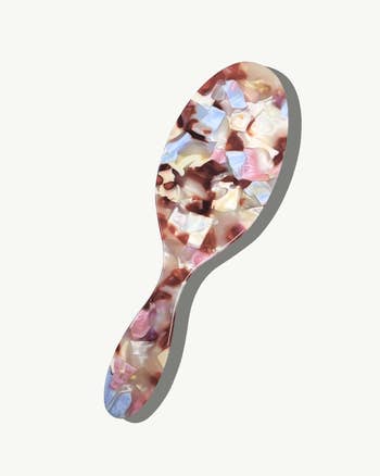 Hairbrush with a marbled design featuring a blend of earthy and pastel tones, showcased in a shopping article
