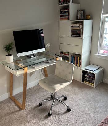 reviewer's home office showing the glass-top desk holding a computer with a chair in front of it