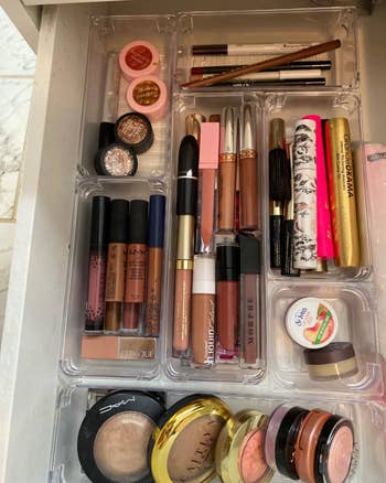 More makeup stacked in rectangular and square containers in reviewer's drawer