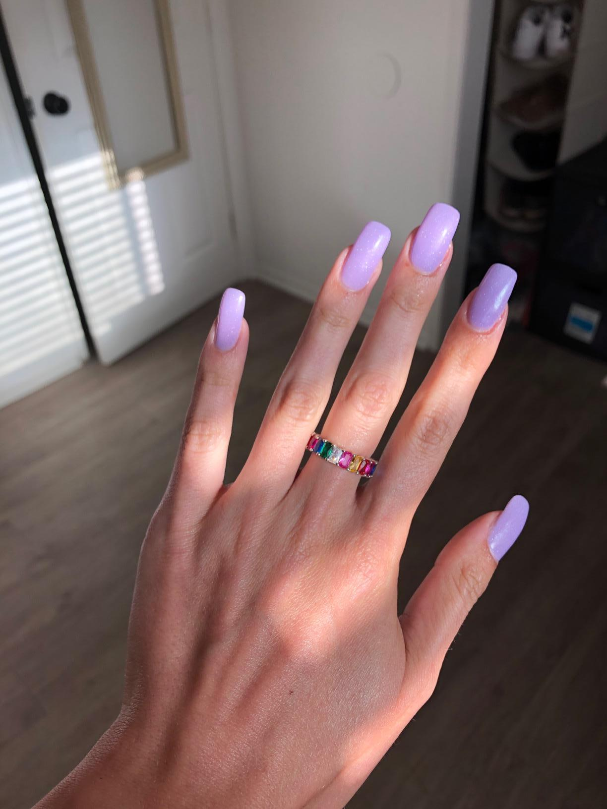 reviewer with long purple nails showing the ring on their finger