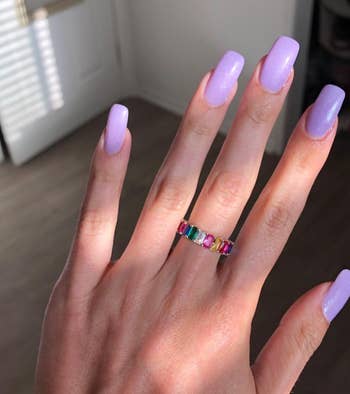 reviewer with long purple nails showing the ring on their finger