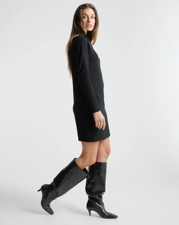 another model wearing the dress in black paired with heeled leather boots