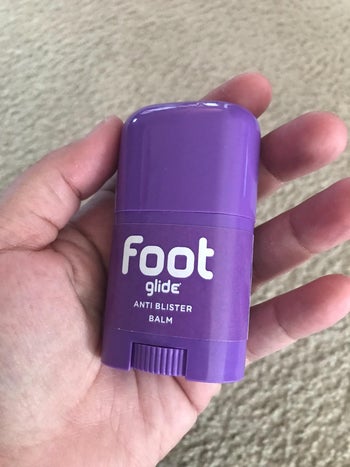 reviewer holding the purple container of balm