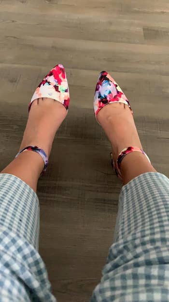 Person in gingham trousers wearing floral patterned ankle strap shoes, view from above