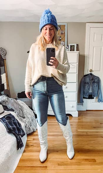 reviewer wearing the white boots with a sweater and jeans