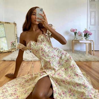 model taking a selfie while wearing the dress in apricot with pink flowers  