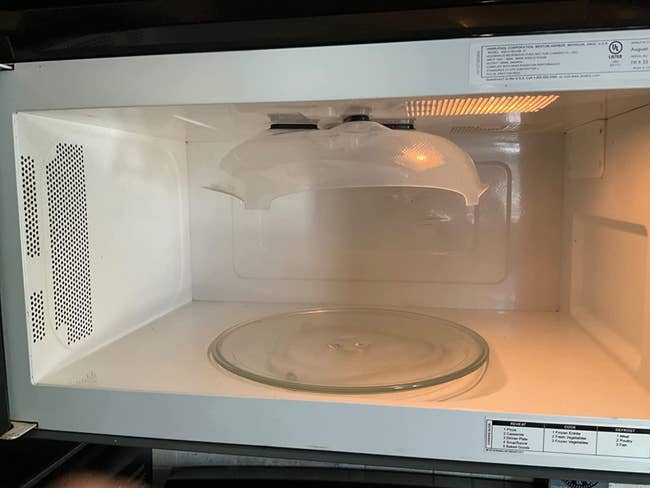The splatter cover attached to the top of the microwave
