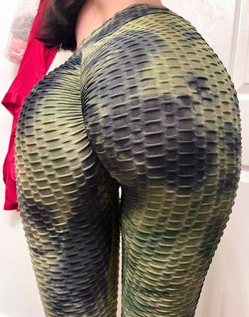close-up of reviewer wearing the same leggings in a black and green color