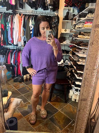a reviewer in an off the shoulder top and shorts in purple