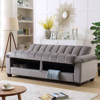 lifestyle photo of the couch in gray, showing storage space underneath