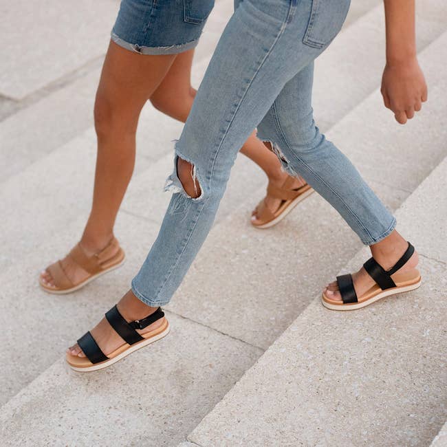 two models each wearing flatform sandals in black and tan