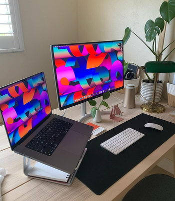 a laptop on the stand next to a full sized monitor