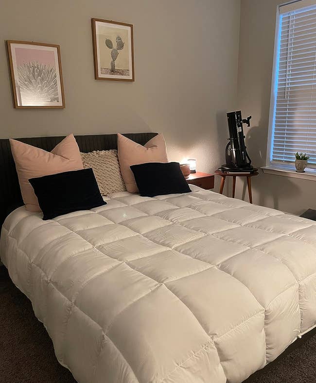reviewer's white all-season comforter on a bed