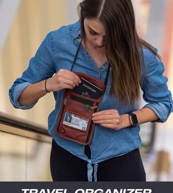 a model with the rust colored neck wallet, showing how a passport, ID, and other items fit inside