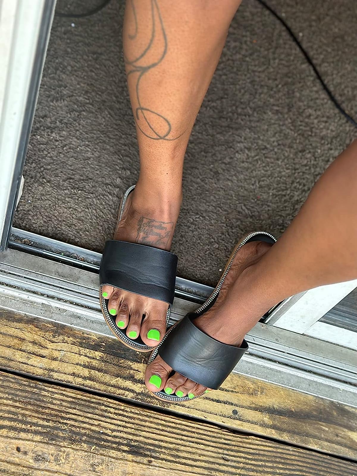 reviewer in sandals with press on toenails that look like regular painted toenails