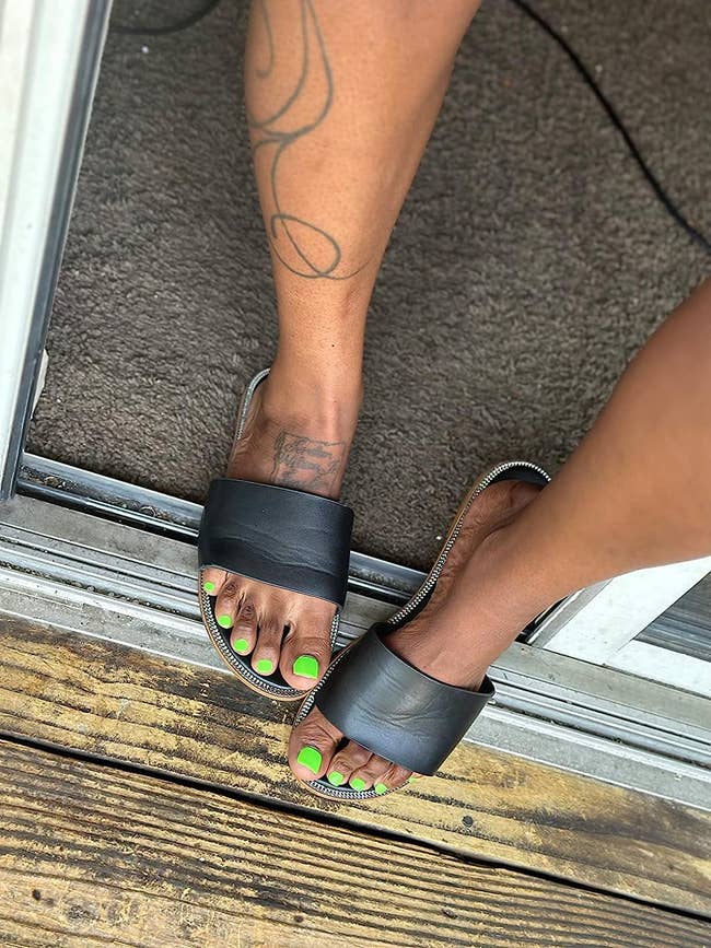 reviewer in sandals with press on toenails that look like regular painted toenails