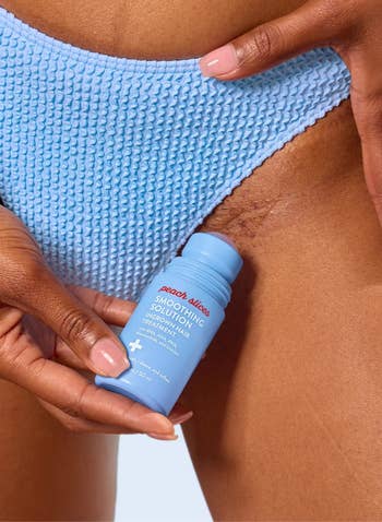 Person applying peach slices smoothing solution   to interior  thigh. Waffle-textured bluish  garment visible. Product aimed astatine  improving tegument  texture