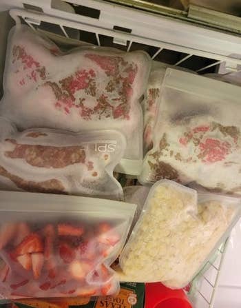 reviewer's freezer containing four of the reusable bags holding various produce and other food items