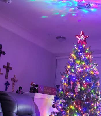 reviewer photo of the star topper projecting colorful lights onto a ceiling