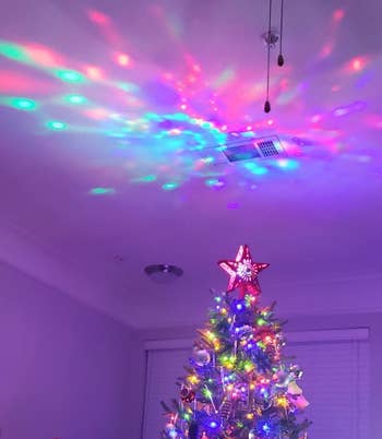 reviewer photo of the star topper projecting colorful lights onto a ceiling