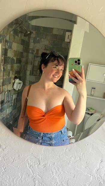 a reviewer wearing the top in orange