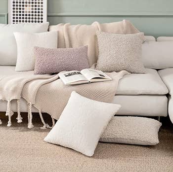 the pillow covers in multiple sizes and colors on a white sofa