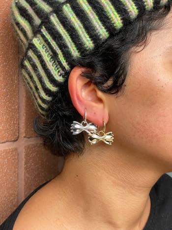 Model wearing the silver and gold earrings in one ear