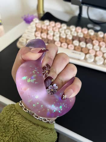 Person holds a purple accent   shot  with sparkles inside