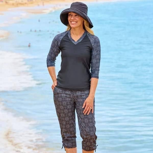 Woman in casual beachwear with hat standing by the shore for a shopping feature