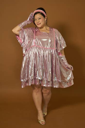 model poses in a glossy, shimmering pink dress