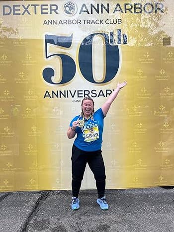 A reviewer celebrating with a medal in front of a 