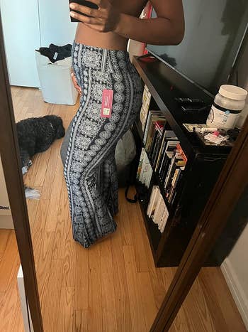 pregnant reviewer posing to the side in blue print version of leggings
