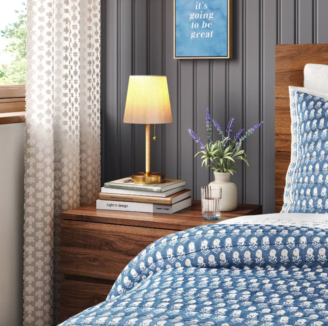 brass and rattan lamp atop a stack of books on a nightstand