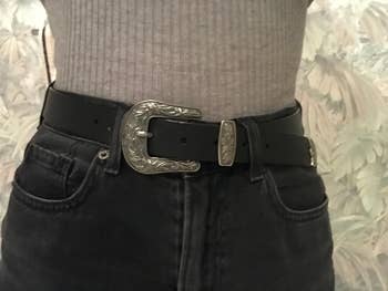 reviewer in black belt with silver tone western buckle worn with high waisted jeans