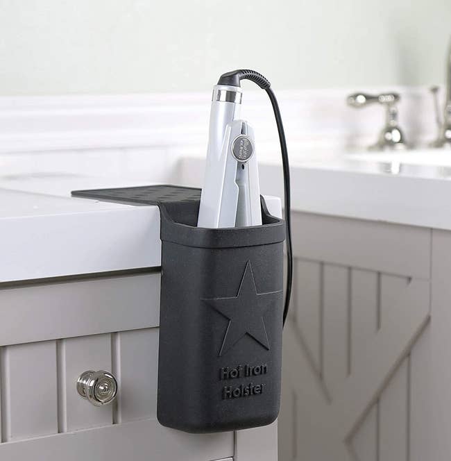 The silicone holster on a bathroom counter with a flat iron placed inside