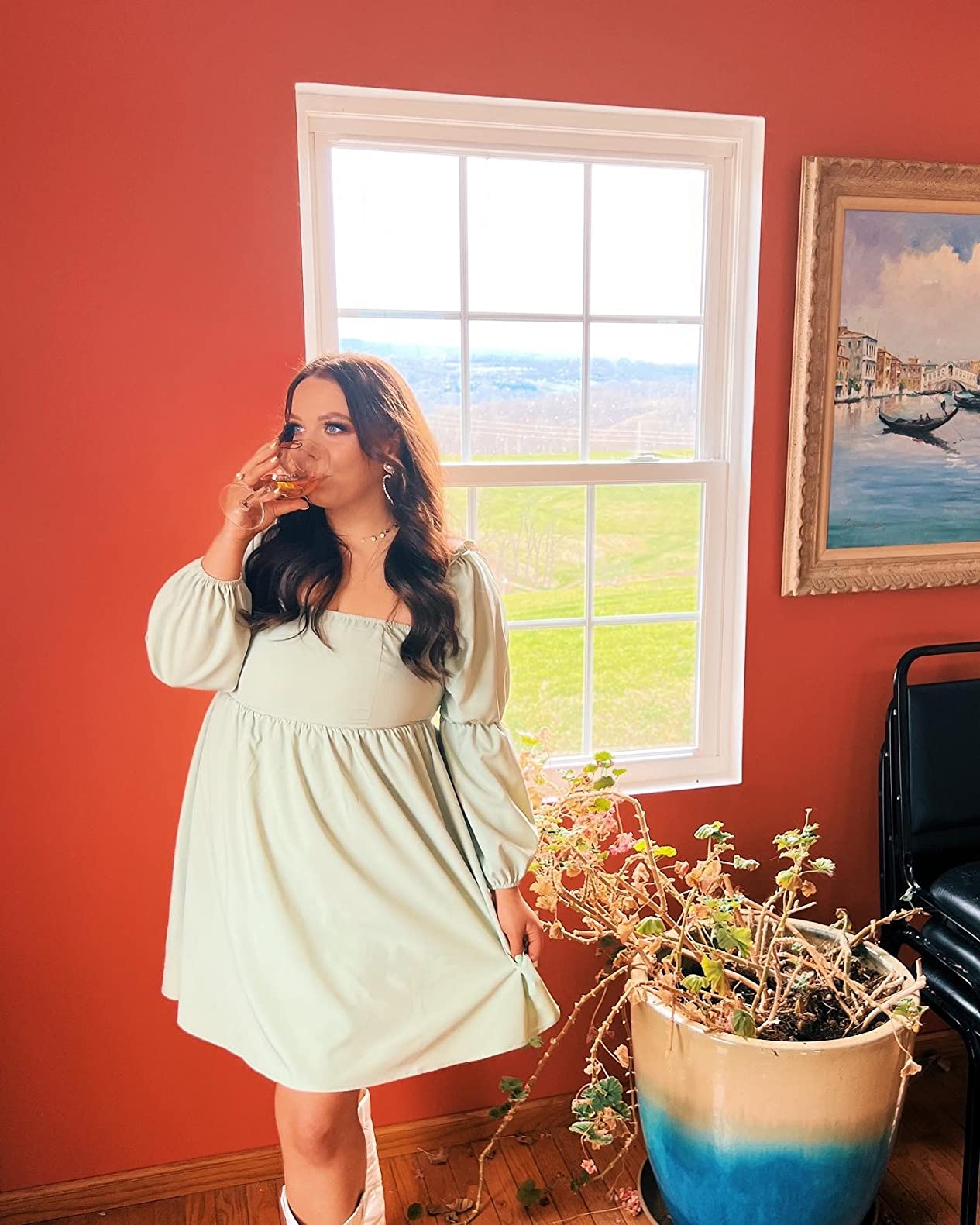 A reviewer successful  a airy  formal  enjoys a portion  by a window, lasting  adjacent  to a ample  potted plant, successful  a stylish indoor setting