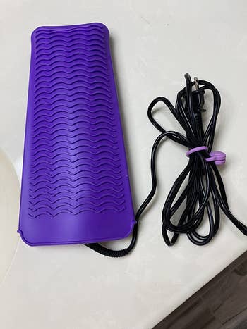 Reviewer photo of the purple silicone mat with the iron inside it