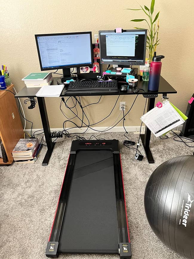 reviewer image of the black treadmill under a standing desk