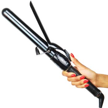 Hand holding a Le Angelique hair straightener, suitable for a shopping article on hair styling tools