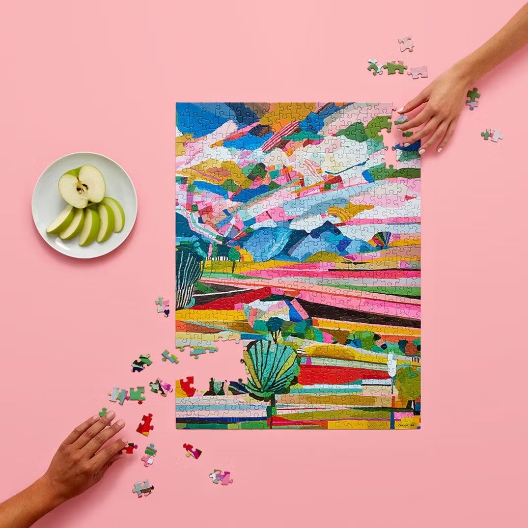 two hands putting together puzzle