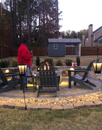 several of the led lit bluetooth speakers hung around a fire pit
