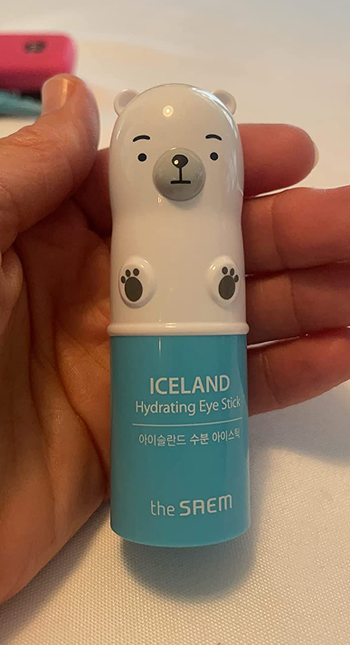 reviewer holding their blue hydrating stick with the top shaped like a polar bear