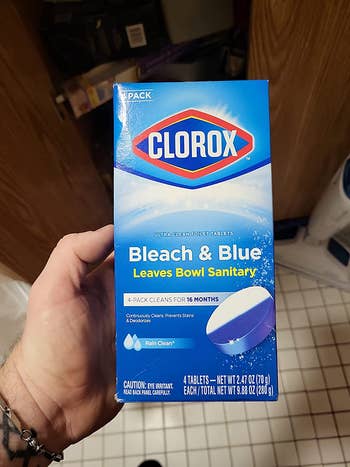 Reviewer holding their pack of Clorox toilet tabs