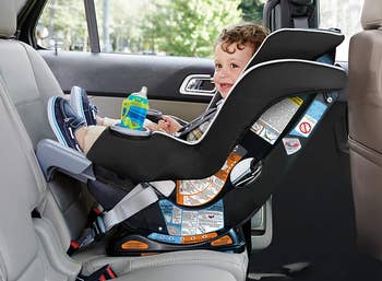 child sitting in rear-facing car seat in backseat