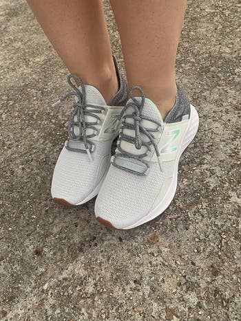 reviewer wearing the white sneakers with grey laces